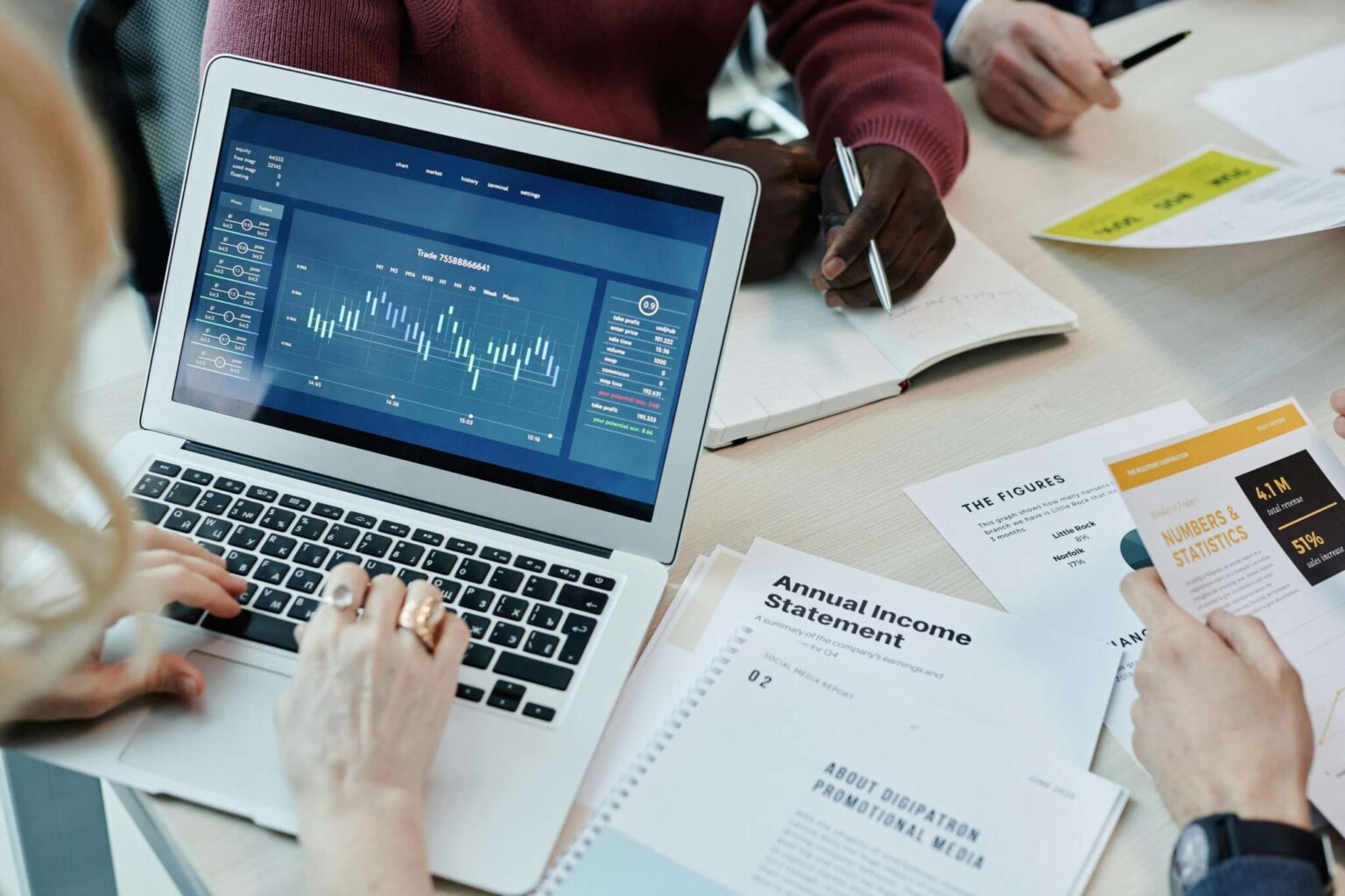 Equipe analisando dados e relatório salarial em notebook