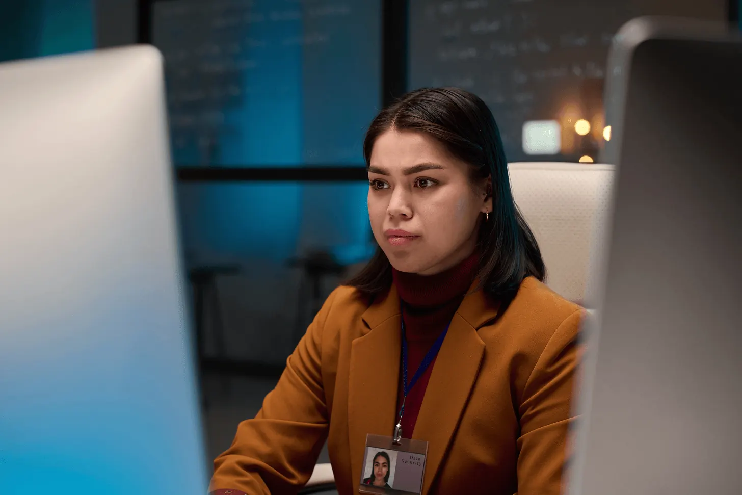 Profissional de tecnologia concentrada diante de computadores