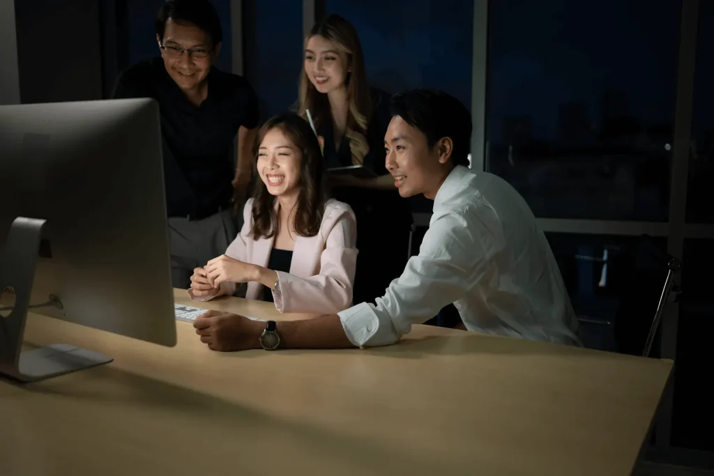 Equipe de tecnologia colaborando diante de um computador