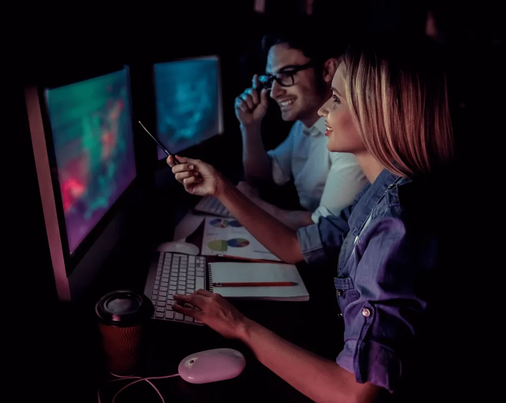 Profissionais de tecnologia trabalhando juntos à noite