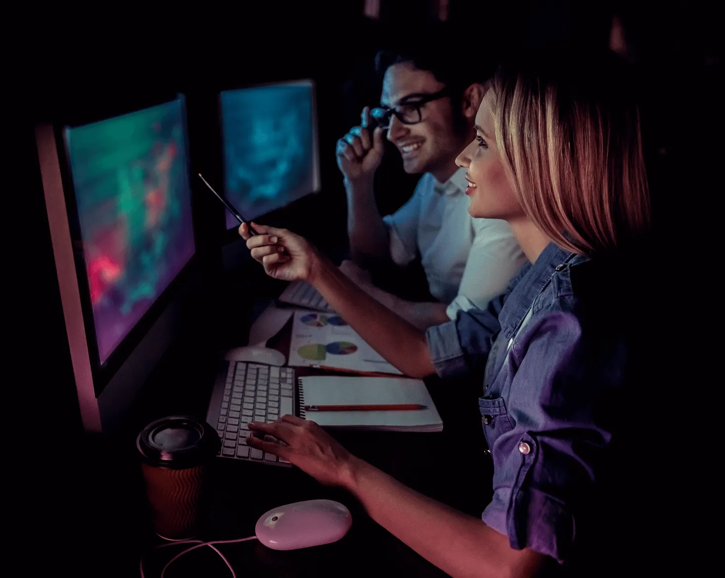 Profissionais de tecnologia trabalhando juntos à noite