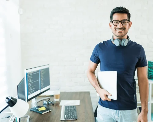 Desenvolvedor trabalhando em home office diante de monitores