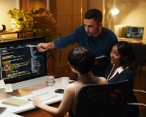 Developer explaining details in programming code his colleagues from front end team