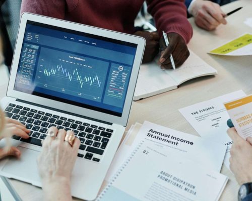 Equipe analisando dados e relatório salarial em notebook